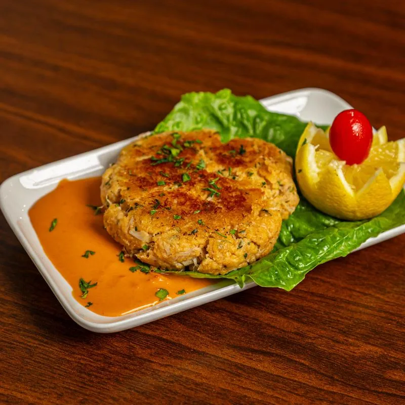 Crab cake over lettuce with carved lemon