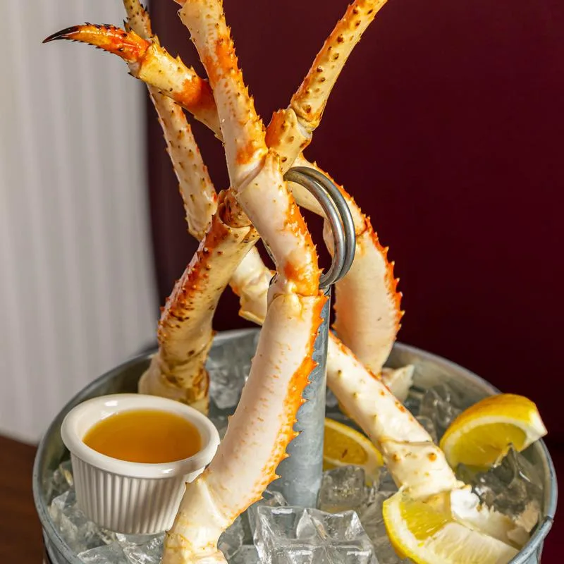Seafood tower with king crab legs, drawn butter and lemon on ice